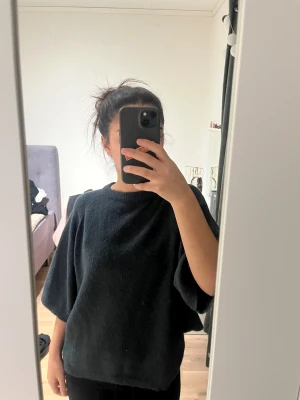 Svart stickad tröja med vida ärmar - Mysig svart stickad tröja som har en fin kall grön färg som är väldigt fin för vintern. Den är gosig och varm.