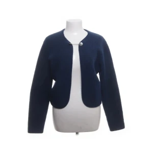 Marinblå kofta med knapp - Snygg marinblå kofta med rund hals och en dekorativ silverfärgad knapp framtill. Perfekt för dig som gillar stilrena och tidlösa plagg. Materialet känns mjukt och värmande, passar perfekt över en T-shirt nu i vinter! 