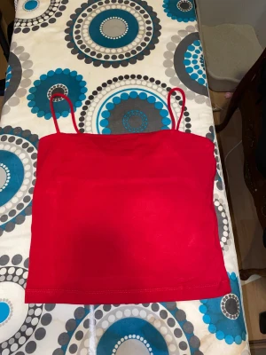 Röd linnetopp från Gina Tricot - En enkel och snygg röd linnetopp från Gina Tricot i storlek S. Toppen har smala axelband och är figurnära med rak skärning. 