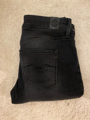 Replay Hyperflex svarta skinny jeans - Svarta Replay Hyperflex jeans i modellen New Luz. Jeansen har skinny passform, klassiska fem fickor och diskreta Replay-detaljer på bakfickan. Stretchigt material för extra komfort och snygg siluett. Perfekta för dig som gillar en tight look.