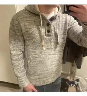 Grå unik stickad hoodie - Otroligt fet grå unik stickad hoodie. Perfekt nu till kallare väder. Modellen är 180cm, 75kg. Storlek L men sitter mer som M. Bara att höra av sig vid frågor och funderingar. Priset kan såklart diskuteras!