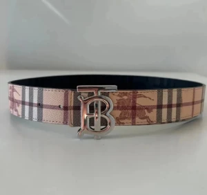 Burberry bälte - Snyggt vändbart bälte från Burberry med klassiskt rutmönster i beige, rött och svart på ena sidan och mörkblått rutmönster på andra. Metallspänne med ikoniska TB-loggan framtill. Tillverkat i läder med lyxig känsla och detaljerad finish. Bältet kan byta till 2 olika färger, har använt det 1-3 gnr mycket bra skick och ser nytt ut.  Kom dm för eventuella frågor🧐, pris kan diskuteras 💯. 