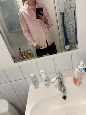 Ralph Lauren skjorta rosa/vit - En snygg rosa/vit randig skjorta från Ralph lauren i storlek L/XL En väldigt liten missfärgning på insidan av kargen som knappt går å se och definitivt inte går å se när man har på sig den efter som att det är på insidan. Kontakta för fler bilder! 