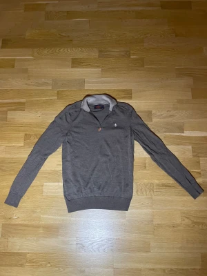 Brun merinoulltröja från Morris  - Snygg brun långärmad tröja från Morris i 100% merinoull. Tröjan har en stilren krage med half zip-dragkedja och diskret logga på bröstet. Den har ett litet hål som man ser på sista bilden men den syns inte.