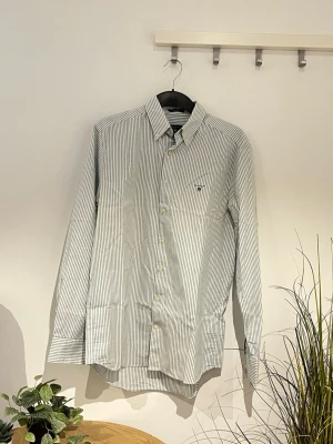 Gant Randig skjorta  - Randig skjorta ifrån Gant. Den är i storlek M och är i fint skick.På andra bilden syns Modellen som är 177cm lång. Den strycks självklart innan vi skickar iväg den🤟🏻