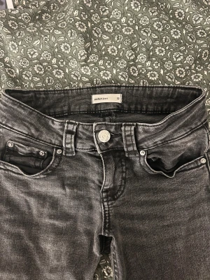 Svarta jeans från Perfect Jeans, storlek 32 - Snygga svarta jeans från Perfect Jeans i storlek 32. Modellen har klassisk femficksdesign med silverfärgade knappar och bälteshällor. Jeansen har en tvättad look och raka ben, vilket ger en cool vibe. Materialet är jeans och passformen är normal.