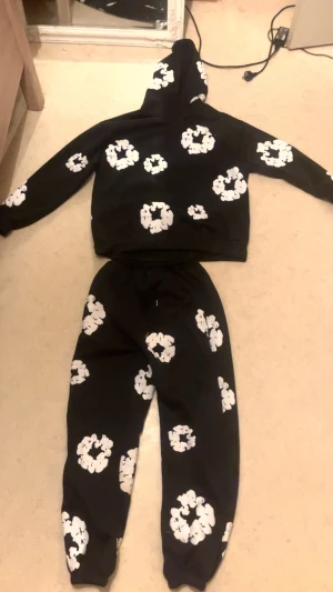 Denim tears tracksuit - Jag säljer min helt nya Denim Tears tracksuit i svart med vita blommor. Jag fick den för bara två dagar sedan, men tyvärr var den för stor för mig.