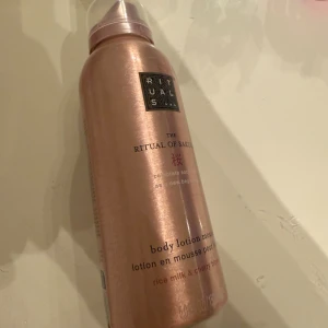 Rituals The Ritual of Sakura body mousse - Oanvänd Rituals The Ritual of Sakura body lotion mousse med risextrakt och körsbärsblom. Flaskan är metallicrosa med svart logga och har en praktisk pump. Mjukgörande och lyxig mousse som ger huden en fräsch doft och silkeslen känsla.