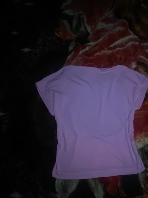 Ljuslila kortärmad topp - Säljer en enkel och stilren ljuslila topp med korta ärmar. Toppen har en rund halsringning och är gjord i ett mjukt material som känns skönt mot huden. Perfekt att matcha med jeans eller kjol för en chill look.