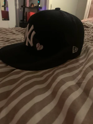 Svart New Era baseball keps - Säljer nu en svart New Era keps med mycket snygg design, mycket mycket bra skick, som ny, storlek 7 3/8, 58,7 cm, har du frågor eller funderingar osv så bara att höra av sig!!☺️