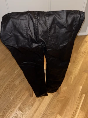 Svarta skinny jeans Snake från 157 - Svarta jeans från 157, modell Snake med hög midja och skinny fit. Byxorna har en slät finish och klassiska bakfickor. Passar dig som gillar tajta och stilrena jeans med modern look. Midjemått 29-30 tum.