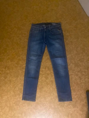 Replay Anbass Slim Fit jeans blå 31 - Pris kan diskuteras❗️Säljer ett par blå Replay Anbass Slim Fit jeans i storlek 31. Klassisk femficksmodell med snygga slitningar och detaljer på bakfickorna. Jeansen har smal passform och är tillverkade i mjukt denimtyg för en bekväm känsla.