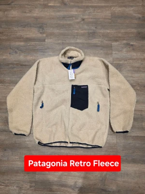 Patagonia Retro beige fleecejacka - Iconic Patagonia fleece with that clean retro outdoor look everyone wants right now. Patagonia Classic Retro-X full zip fleece in a timeless beige colorway with contrast chest pocket. Thick pile fleece, boxy fit and wind-blocking lining make it both functional and stylish. Perfect for streetwear, workwear layering or everyday winter wear. ⭐️ ORIGINAL ⭐️  📏 Measurements: Length (A): 72 cm Width / Chest (D): 68 cm Shoulder-to-cuff (B): 61 cm Pit-to-cuff (C): 56 cm  Condition: New with tags Size: XL