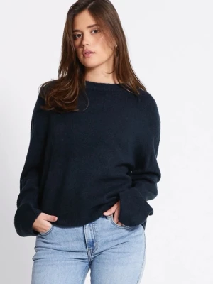 Mörkblå stickad tröja  - Mysig mörkblå stickad tröja med avslappnad, loose passform och långa ärmar. Perfekt för lager-på-lager och enkel att styla med jeans eller kjol. Tröjan har en klassisk rund halsringning och breda muddar vid ärmsluten.