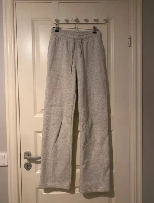 sweatpants straight leg - Mjukisbyxor med normal passform. Byxorna är gråa och har fickor i sidorna. De har raka ben och resår i midjan med knytning framtill. Lite nopprig upptill men annars inga defekter.   material	Bomull 70%, Polyester 30%