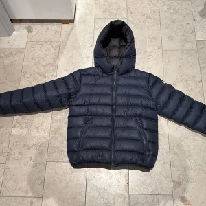 Mörkblå dunjacka med luva från Colmar - Snygg mörkblå dunjacka från Colmar med luva . Perfekt för kalla dagar🙌 hör av er om frågor finns en superliten defekt på baksidan på lilla colmar märket men annars nyskick 🤗nypris 4499kr! Kan diskutera pris 🙌