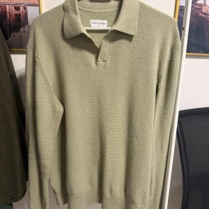 Ljusgrön pikétröja från These Glory Days - Säljer en stilren ljusgrön pikétröja från These Glory Days. Tröjan har klassisk krage, lång ärm och är tillverkad i ett strukturerat bomullstyg. Perfekt för dig som gillar en clean och avslappnad look.