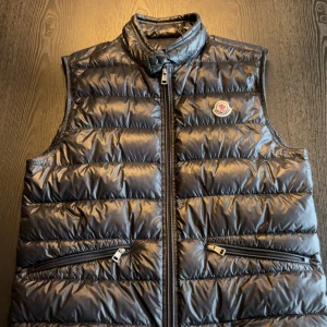 Moncler Gui Väst Size 3 - Svart Moncler Gui väst i storlek 3, vilket är storlek M. Väldigt bra skick och inga flaws eller fel på den. Bara västen, inget kvar från köp. Den är köpt i high end swedens facebook grupp.