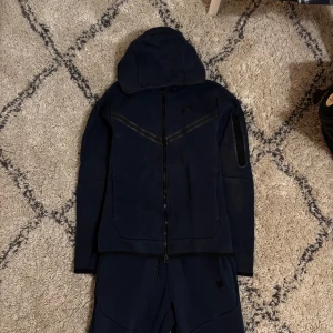 Mörkblå hoodie från Nike med dragkedja - Mörkblå nike tech i storlek xs, säljer för att jag inte använt på länge. Tveka inte på att höra av dig vid minsta lilla fundering!