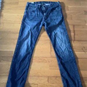 Emporio Armani jeans - Snygga blå jeans från Emporio Armani med klassisk femficksdesign och diskret logga på bakfickan. Jeansen är tillverkade i ett lätt denimtyg på 9,5 oz och har raka ben med normal passform. Perfekta för dig som gillar stilrena och tidlösa jeans.