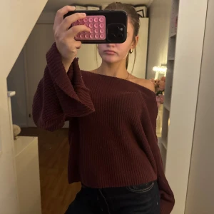 Vinröd stickad offshoulder-tröja - Vinröd stickad tröja med breda trumpetärmar och offshoulder-passform. Säljer en jätte fin mysig vinröd stickad tröja med utsvängda armar, inget som sticks och väldigt mysigt material, perfekt för höst och vinter med riktigt bra färg. Xs-M, Från NA-KD