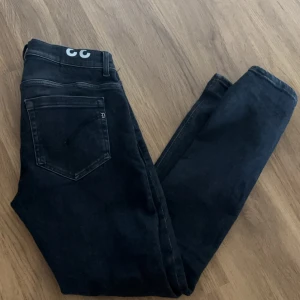 Svart/gråa jeans från Dondup, stl 33 - Snygga svartgåra jeans från Dondup i klassisk. Jeansen har raka ben och normal passform, tillverkade i mjukt denimtyg. Perfekta för dig som gillar stilrena och tidlösa jeans med diskreta detaljer.