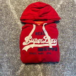 Superdry hoodie - En röd Superdry hoodie i storlek M den är i bra skick det är bara att fråga vid minsta intresse:)