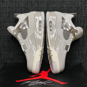 Nike Air Jordan 4 Metallic Silver - Nike Air Jordan 4 i en clean beige och silverfärg med metallic-detaljer. Ovandelen kombinerar skinn och mocka med meshpaneler och silvriga accenter på snörningen. Klassisk Air-dämpad sula och ikonisk Jumpman-logga på undersidan. Perfekt för dig som vill sticka ut.