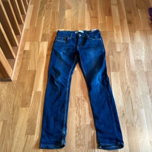 Levi's 512 Slim Taper jeans blå - Snygga Levi's 512 Slim Taper jeans i klassisk mörkblå denim. Modellen har smal passform med avsmalnande ben . Perfekta för dig som gillar en modern och stilren look. Bra skick de ända som är lite slitet de är lappen där back.
