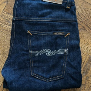 Mörkblå jeans från Nudie Jeans - Säljer ett par mörkblå jeans från Nudie. Modell: Thinn Finn. Storlek: 30-32 Jeansen är bara använda ett fåtal gånger och är därför i otroligt bra skick med minimala tecken på användning. Jeansen är köpta nyligen, nypris 1600kr ❌  Jag säljer för endast 649kr✅självklart kan pris diskuteras! Hör av er vid minsta fundering. 
