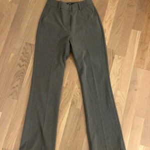 Grå kostymbyxor med lite bootcut - Grå kostymbyxor med bootcut passform. Halvt lågmidjade, väldigt stretchiga och mjuka.
