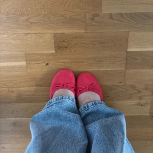 Röda ballerina skor - Supersöta röda ballerina skor med rundad framsida och rosett. Helt oanvända. Storlek 40 men möjligen lite stora i storleken. 