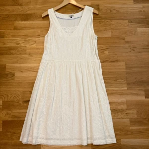 Säljer Vit ärmlös klänning Hampton Republic! - Klänningen är helt ny och  är endast använd ett fåtal gånger.  Storlek på klänningen: 43.  Superfin vit klänning från Hampton Republic med broderade hålmönster och v-ringning. Den är ärmlös, har en lätt utställd kjol och är gjord i bomull. Perfekt för varma dagar när du vill känna dig både söt och bekväm.