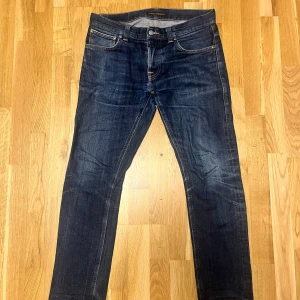 Nudie Jeans Selvage Grim Tim - Säljer de snyggaste jeansen jag har som är i japanskt selvage i modellen Grim Tim från Nudie Jeans. Det är dry deep selvage som är listad som färg. Bra att veta att dessa sitter mer som en 30-31 i midjan. Jeansen är använda i nästan ett år och de blir snyggare för varje användning!