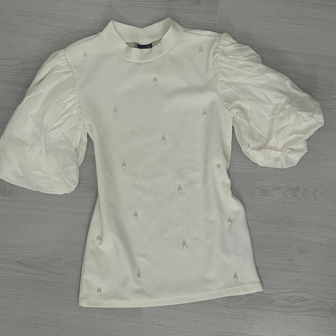 Vit blus med puffärmar och pärlor