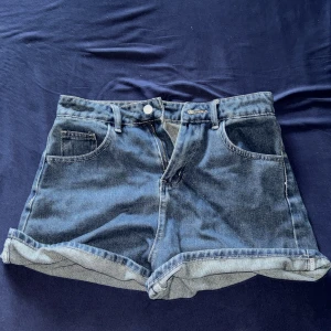 Blå jeansshorts från Dazy, M - Snygga blå jeansshorts från Dazy i klassisk femficksmodell med uppvikta benslut. Har aldrig använt dom för att dom e för stora.