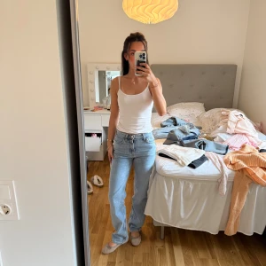 Ljusblå raka jeans med medel hög midja - Säljer ett par ljusblå jeans med klassisk femficksdesign och raka ben. Jeansen har medel hög midja och är tillverkade i ett mjukt denimtyg som ger en avslappnad och snygg look. Perfekta att styla med sneakers eller ballerinas 💙endast använda en gång 