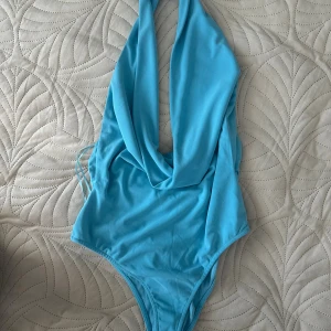 Blå halterneck body med öppen rygg - Supersnygg blå body från Zara .Perfekt för dig som vill sticka ut med en fräsch färg i sommar.