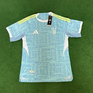 Juventus 25/26 fotbollströja adidas  - Juventus fotbollströja från Adidas i ljusblått med unikt abstrakt mönster och vita detaljer. Tre gula ränder på axlarna, vit krage och meshpaneler på sidorna för extra ventilation. Tillverkad i lätt polyester, perfekt för träning eller match.