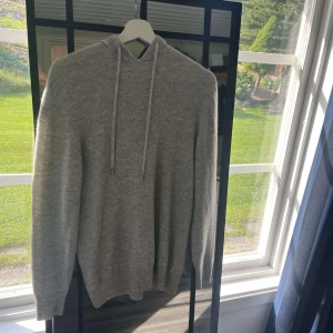 Merinoull hoodie  - En grå Hoodie i merinoull. Tröjan är i bra skick och har inga defekter. Vid fler frågor eller bilder hör av er. 