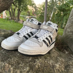 Adidas Forum Mid Cloud Vit/Svart 39⅓ - Storlek 39/40Adidas Forum Mid sneakers perfekta för dig som gillar retrostil och streetwear.                                                                             Nypris 1775