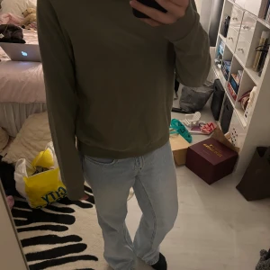 Olivgrön sweatshirt - En  olivgrön sweatshirt från lager 157 i storlek M. Tröjan har rund halsringning, ribbade muddar vid ärmslut och nederkant samt en avslappnad passform. Perfekt för en chill och enkel stil. Materialet är mjuk bomull.