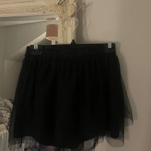 Svart puffig minikjol   - En svart kortkjol i flera lager tyll som ger extra volym och fluffig look. ⚡️ 