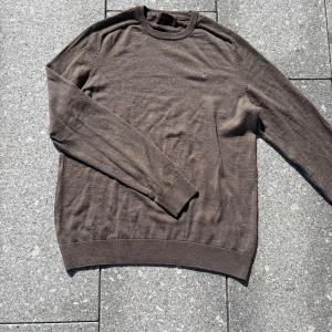 Brun ulltröja från Morris XL - Snygg brun stickad tröja från Morris i 100% merinoull. Klassisk rund halsringning och diskret broderad logga på bröstet. Perfekt för dig som gillar stilrena och tidlösa plagg med en chill vibe.