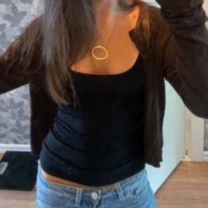 Brun kofta från 157, storlek S - Mörkbrun kofta från 157 i storlek S. Den har rund halsringning, långa ärmar och knäppning framtill med flera knappar. Perfekt att slänga över en topp eller klänning. Materialet känns mjukt och lätt, troligen bomull eller syntet.
