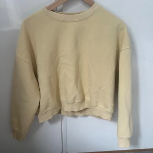 Gul sweatshirt från 157, XS/S - En enkel och oversized ljusgul sweatshirt från 157 med rund hals och ribbade muddar. Mjuk insida och avslappnad passform, perfekt för chill dagar. Tillverkad i bomullsmix och passar dig som gillar basic och comfy stil. Har tre fläckar som inte går bort 