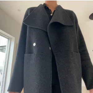 Mörkgrå kappa  - Säljer denna Suuuuper snygga kappa från Wera! Tyvärr tycker jag den är lite kort och liten för mig nu och därför säljer jag den (är ungefär 1.72)🥰 Använd fåtal gånger så verkligen i super fint skick! Nypris 2000, priset går såklart att diskutera✨💞