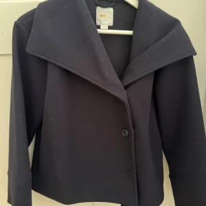 Svart kavajjacka från Gina Tricot - Snygg marinblå kappa från Gina Tricot Young  med bred krage och enkel knappstängning framtill. 