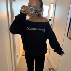 Mörkblå offshoulder hoodie Gina Tricot - Mörkblå hoodie från Gina Tricot med vit text framtill. Tröjan har offshoulder-krage. Ordinarie pris 359.  Str 158/164. Aldrig använd