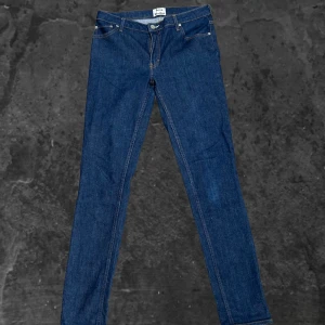 Blå jeans från Acne Studios - Snygga blå jeans från Acne Studios i modellen Flex Raw Reform. De har klassisk femficksdesign, smal passform och är tillverkade i en stretchig bomullsblandning för extra komfort. Perfekta för dig som gillar stilrena och tidlösa jeans.
